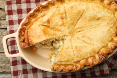 Tavuklu ve sebzeli lezzetli ev yapımı turta ahşap masada, üst tarafta.