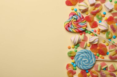 Bej arka planda bir sürü lezzetli şeker ve marşmelov var. Metin için boşluk