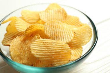 Lezzetli patates cipsleri beyaz masada, yakından.