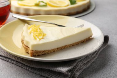 Gri desenli masada lezzetli limonlu cheesecake, yakın plan.