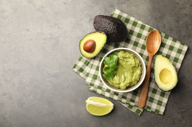 Lezzetli avokado sosu, maydanoz ve gri masada meyveler, düz yatak. Metin için boşluk