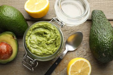 Lezzetli avokado sosu cam kavanoza, meyveler ahşap masaya.