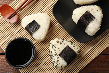 Pirinç topları (onigiri), soya sosu ve ahşap masa üzerindeki çubuklar, düz yatak. Geleneksel Japon yemeği