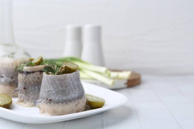 Turşulu ve dereotlu lezzetli ringa dürümleri açık fayanslı masada, yakın plan. Metin için boşluk