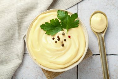 Maydanozlu mayonez sosu, biberler kasede ve kaşıklar fayanslı masada, düz yerde.