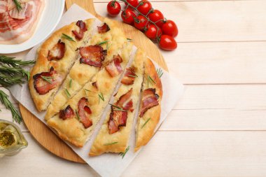 Domuz pastırmalı, biberiyeli, ahşap masada yağlı ve domatesli lezzetli Focaccia ekmeği. Metin için boşluk