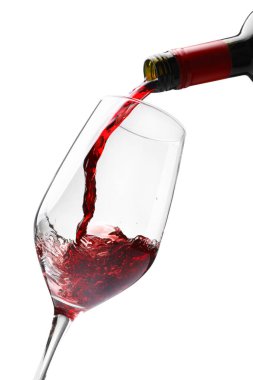 Beyaz bardağa kırmızı şarap dökülüyor.