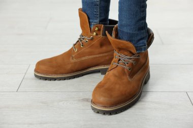 Büyük boy kahverengi çizme giyen çocuk, yakın plan.