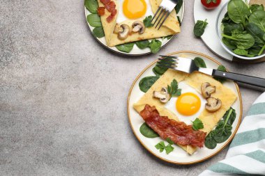 Yumurtalı, pastırmalı ve mantarlı leziz krepler gri masada servis ediliyor. Metin için boşluk