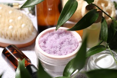 Aydınlık masa üzerinde yaprakları olan farklı vücut bakım ürünleri ve dallar, yakın çekim