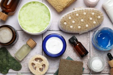Hafif fayanslı masa üzerinde farklı vücut bakım ürünleri, düz uzanma