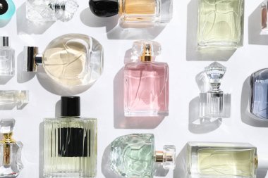 Farklı aromatik parfümler beyaz arka planda şişelerde, düz yerde