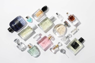 Farklı aromatik parfümler beyaz arka planda şişelerde, düz yerde