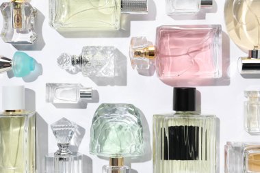 Farklı aromatik parfümler beyaz arka planda şişelerde, düz yerde