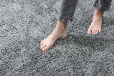 İçerideki yumuşak gri halıdaki kız, yakın plan. Metin için boşluk