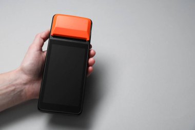 Gri arka planda ödeme terminali olan kadın, yakın plan. Metin için boşluk