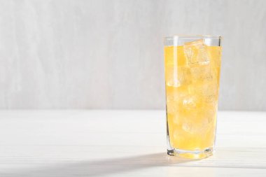 Beyaz ahşap masada buzlu tatlı soda, yazı için yer var.