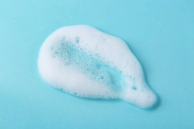 Açık mavi arkaplanda kabarık köpük örneği, üst görünüm