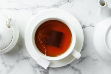 Çay poşeti sıcak içecek ve çaydanlık hafif mermer masada, düz yatıyordu.