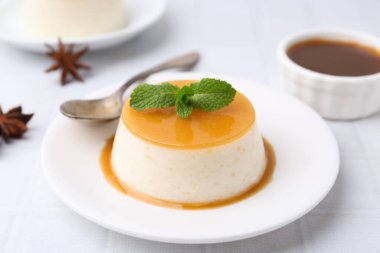 Beyaz fayanslı masada servis edilen karamelli puding, yakın plan.