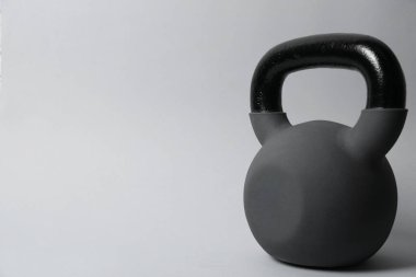 Gri arka planda metal bir kettlebell, mesaj için yer var. Spor malzemeleri.