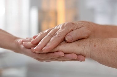 Son sınıf öğrencisine arka planda destek veren bakıcı, yakın plan. Yaşlı bakımı