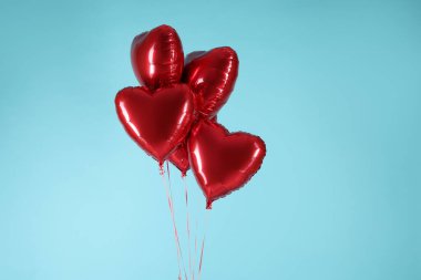 Açık mavi arka planda bir sürü kırmızı kalp şeklinde balon. Sevgililer Günün kutlu olsun.