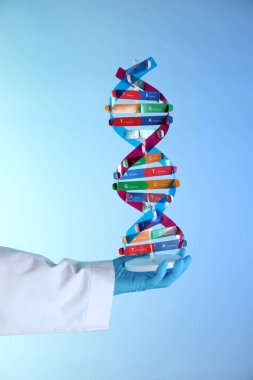 Renk arkaplanı üzerinde DNA yapı modeline sahip bilim adamı, yakın plan