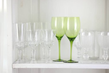 Beyaz rafta farklı boş bardaklar