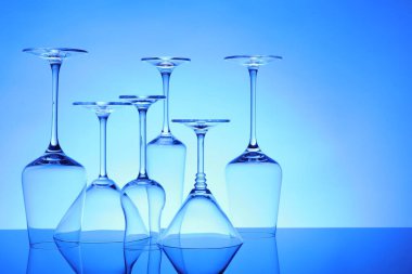 Ayna yüzeyinde birçok boş bardak mavi arkaplana karşı