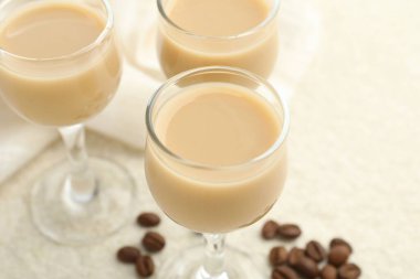 Bardakta kremalı kahve likörü ve beyaz masada fasulye, yakın plan.