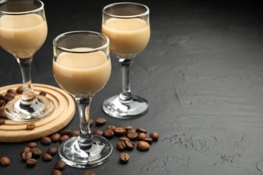 Bardakta kremalı kahve likörü ve siyah masada fasulye, yakın plan. Metin için boşluk