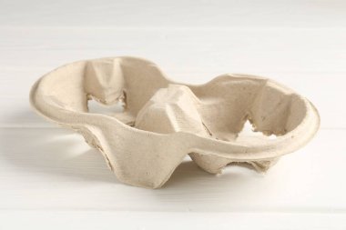 Boş mukavva bardak tutacağı beyaz ahşap masada, yakın plan.