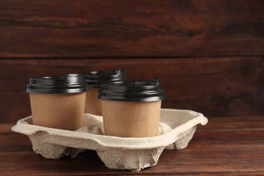 Tahta masadaki karton tutacakta kağıt kahve fincanları. Metin için boşluk