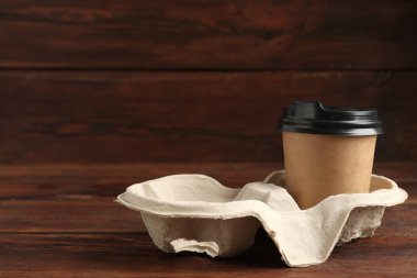 Kağıt kahve fincanı ahşap masanın üzerinde karton tutacakta, yakın plan. Metin için boşluk