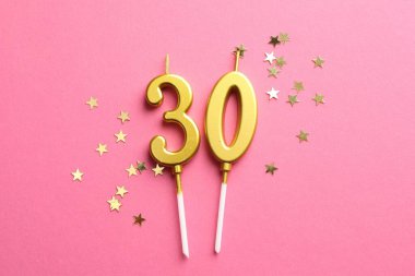 30. yaş günü. Pembe arkaplandaki mumlar ve konfetiler düzdü.