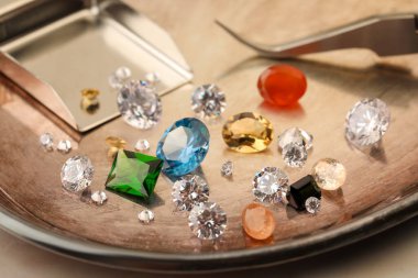 Işık masasında güzel değerli taşları olan tepsi, yakın plan.