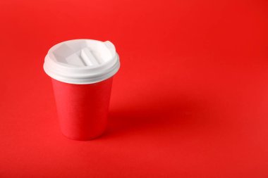 Kırmızı arka planda bir kağıt bardak. Tasarım için model