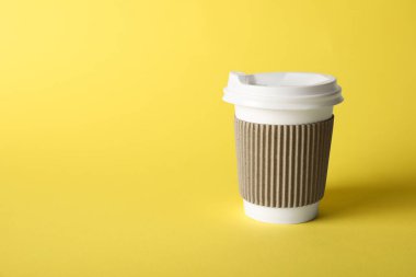 Sarı arka planda bir kağıt bardak. Tasarım için model