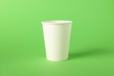 Yeşil arka planda bir kağıt bardak. Tasarım için model