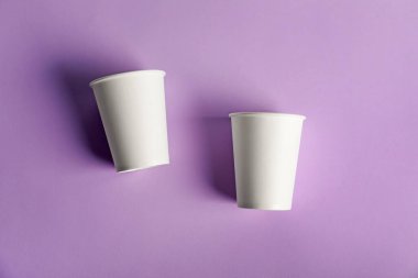 Menekşe arka planda kağıt bardaklar, düz yatış. Tasarım için model