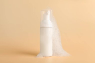 Bej kaplama köpüklü bir şişe kozmetik ürünü.