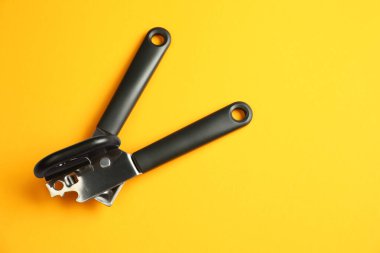 Sarı arka planda bir konserve açacağı, üst manzara. Metin için boşluk