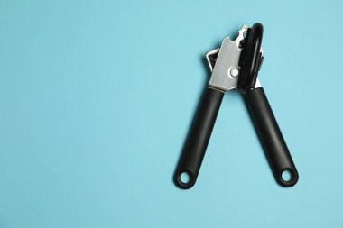 Açık mavi arka planda bir konserve açacağı, üst manzara. Metin için boşluk