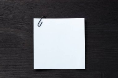 Siyah ahşap masa üzerinde raptiyeli kağıt not, üst manzara. Metin için boşluk