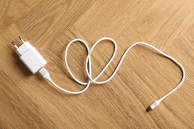 USB güç adaptörü, ahşap masa üzerinde şarj kablosu, üst görünüm