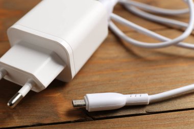 Tahta masada şarj kablosu olan USB güç adaptörü, yakın plan.