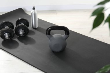 Kettlebell, halterler, termik şişe ve paspas.