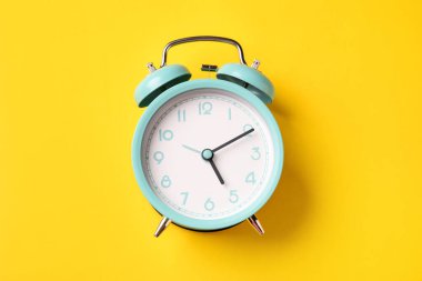 Sarı arka planda turkuaz alarm saati, üst görünüm