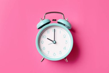 Pembe arka planda turkuaz alarm saati, üst görünüm